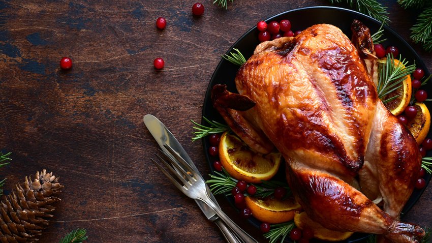 Foto de un pavo entero cocinado servido sobre una mesa.