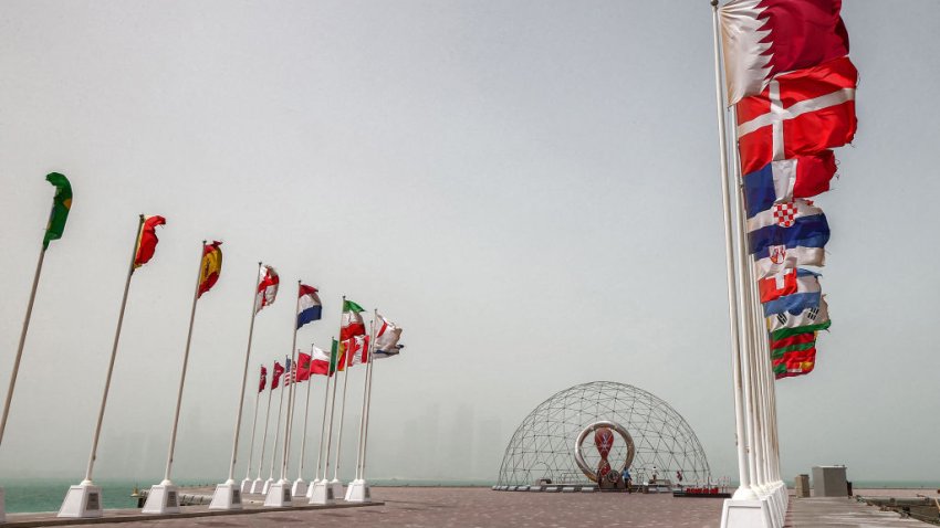 The flags of nations taking part in the Qatar 2022 FIFA World Cup fly Qatar’s capital Doha during a heavy dust storm on May 17, 2022 as the skyline behind is obscured in the haze. (Photo by KARIM JAAFAR / AFP) (Photo by KARIM JAAFAR/AFP via Getty Images)