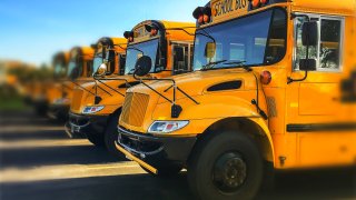 Row,Of,Yellow,School,Buses,Parked,Inline,With,Blurred,Background