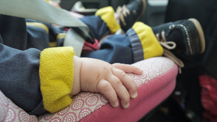 baby sleeping in car seat. No face. Focus on hand