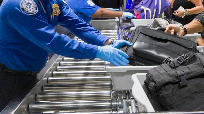 MIAMI, FLORIDA – MAY 21: Transportation Security Administration (TSA) agents help travelers place their bags through the 3-D scanner at the Miami International Airport on May 21, 2019 in Miami, Florida. TSA has begun using the new 3-D computed tomography (CT) scanner in a checkpoint lane to detect explosives and other prohibited items that may be inside carry-on bags.  (Photo by Joe Raedle/Getty Images)