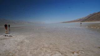 Foto cortesía de NPS tomada por Elyscia Letterman. Visitantes del parque caminando en el lago temporal en Badwater Basin.