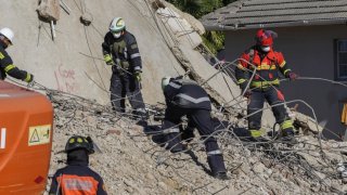 Socorristas buscan entre los escombros de un edificio que se derrumbó en George, Sudáfrica, el jueves 9 de mayo de 2024.