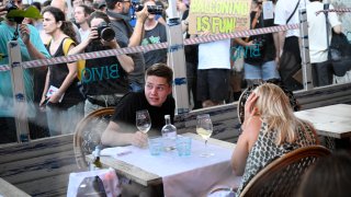 Los manifestantes colocaron un cordón simbólico en la ventana de un bar-restaurante durante una protesta contra el turismo de masas en el callejón de Las Ramblas de Barcelona, el 6 de julio de 2024. Las protestas contra el turismo de masas se han multiplicado en los últimos meses en España, el segundo país más visitado del mundo.