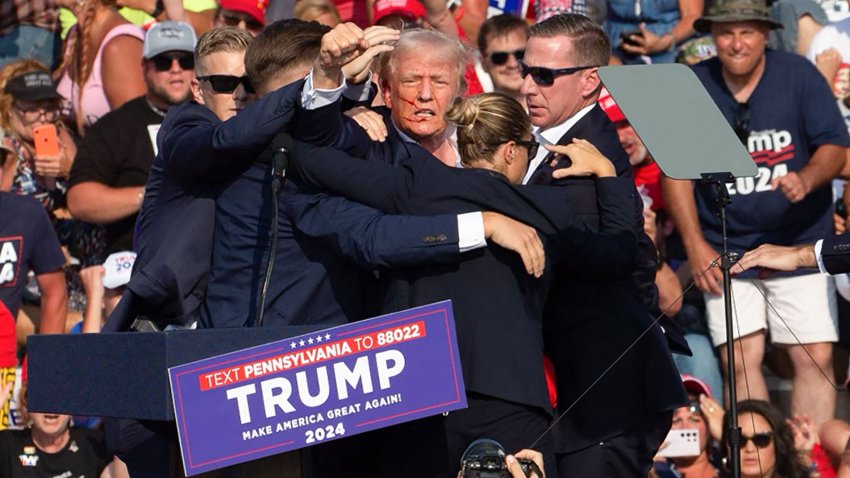 TOPSHOT – Republican candidate Donald Trump is seen with what appears to be blood on his face surrounded by secret service agents as he is taken off the stage at a campaign event at Butler Farm Show Inc. in Butler, Pennsylvania, July 13, 2024. Republican candidate Donald Trump was evacuated from the stage at today’s rally after what sounded like shots rang out at the event in Pennsylvania, according to AFP.
The former US president was seen with blood on his right ear as he was surrounded by security agents, who hustled him off the stage as he pumped his first to the crowd.
Trump was bundled into an SUV and driven away. (Photo by Rebecca DROKE / AFP) (Photo by REBECCA DROKE/AFP via Getty Images)