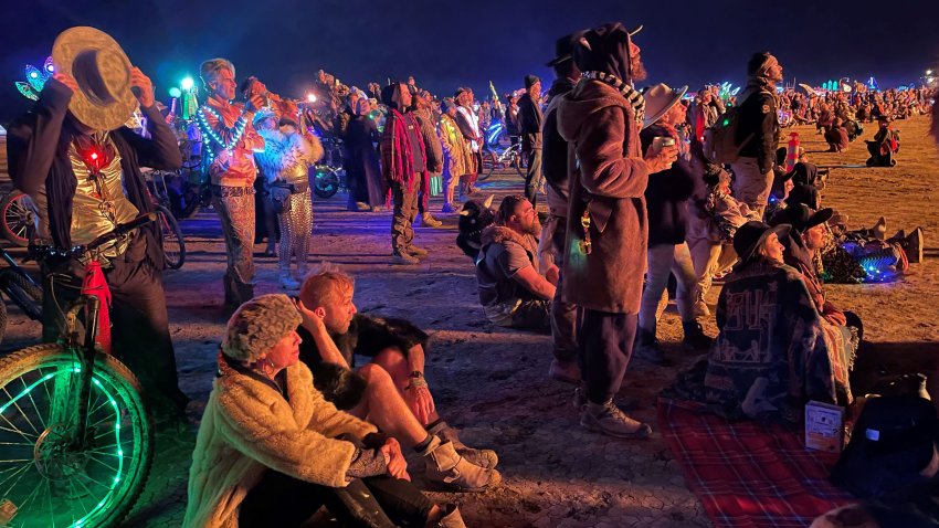 Attendees gather to watch the burning of “The Chapel of Babel,” a work of art by Michael Burlington, during the annual Burning Man Festival in the early morning of September 5, 2023. Thousands of revelers stuck in the mud for days at the Burning Man festival in the US state of Nevada were told they could finally trek home on September 4, 2023, after torrential rain had prompted shelter-in-place orders. With the sun shining on the colorful makeshift community of 70,000 people called Black Rock City, the roads opened Monday afternoon, kicking off the official exit process known as the “Exodus.” (Photo by Julie JAMMOT / AFP) (Photo by JULIE JAMMOT/AFP via Getty Images)