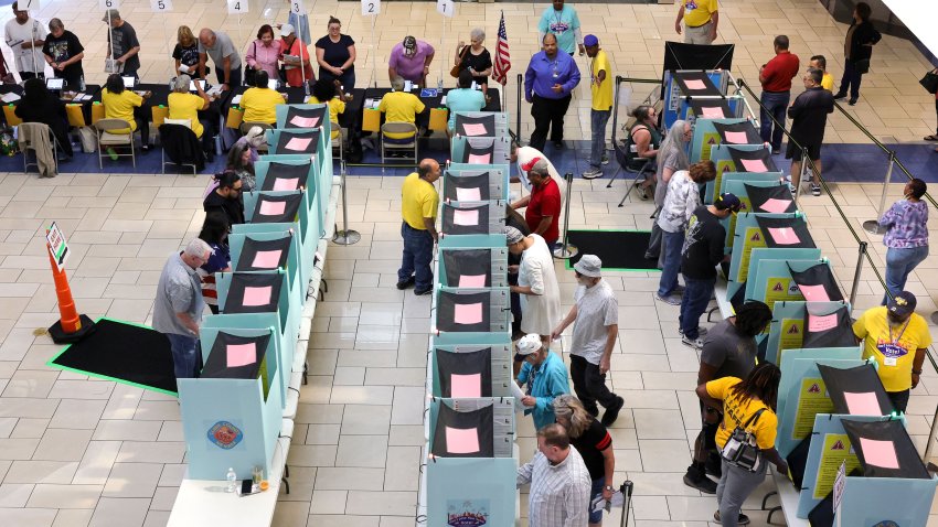 LAS VEGAS, NEVADA – OCTOBER 21: Clark County Election Department poll workers check in voters at a table as people vote at the Meadows Mall on October 21, 2024 in Las Vegas, Nevada. Early voting in the battleground state began on October 19 and continues through November 1. On the first day of early voting, Nevada recorded the most in-person voters since adopting universal mail voting for the 2020 election. (Photo by Ethan Miller/Getty Images)