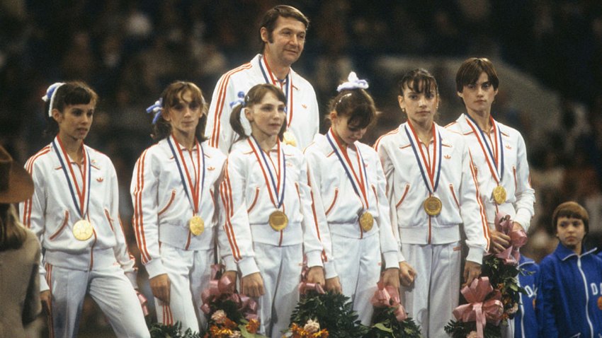 Gymnastics: World Championships: Team Romania coach Bela Karolyi victorious with gymnasts wearing medals during awards ceremony. View of Nadia Comaneci on far right.
Fort Worth, TX 12/7/1979
CREDIT: Jerry Cooke (Photo by Jerry Cooke /Sports Illustrated via Getty Images)
(Set Number: X24006 TK1 R10 F11 )