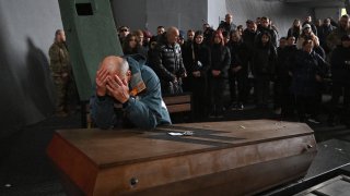 El padre del soldado Daniil Liashkevych llora ante el cajón que contiene los restos de su hijo, quien murió en un ataque ruso junto al amor de su vida, la médica Valentyna Nahorna, en Kiev, este viernes.