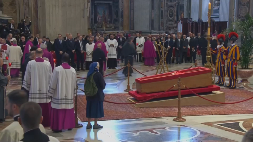 Nun stands in front of Pope's coffin