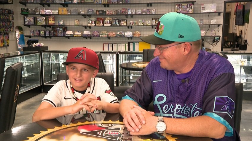 Young boy and his father sit in trading card shop